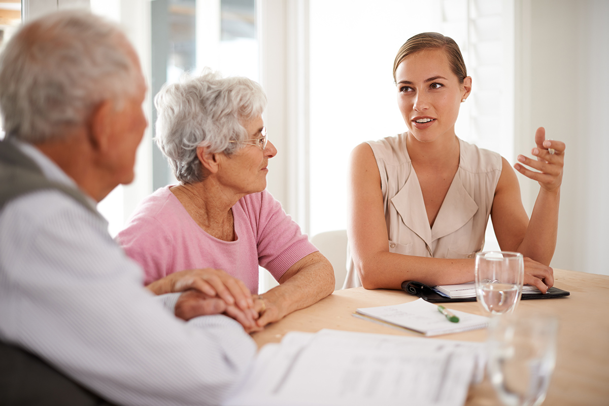 young female lawyer talking with senior couple